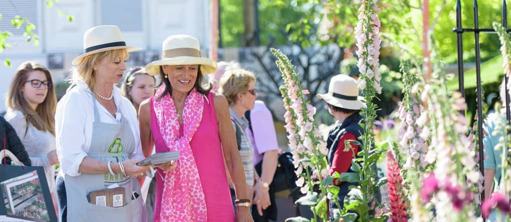 A visitor talks to an exhibitor at The Modern Slavery Garden at the RHS Chelsea Flower Show 